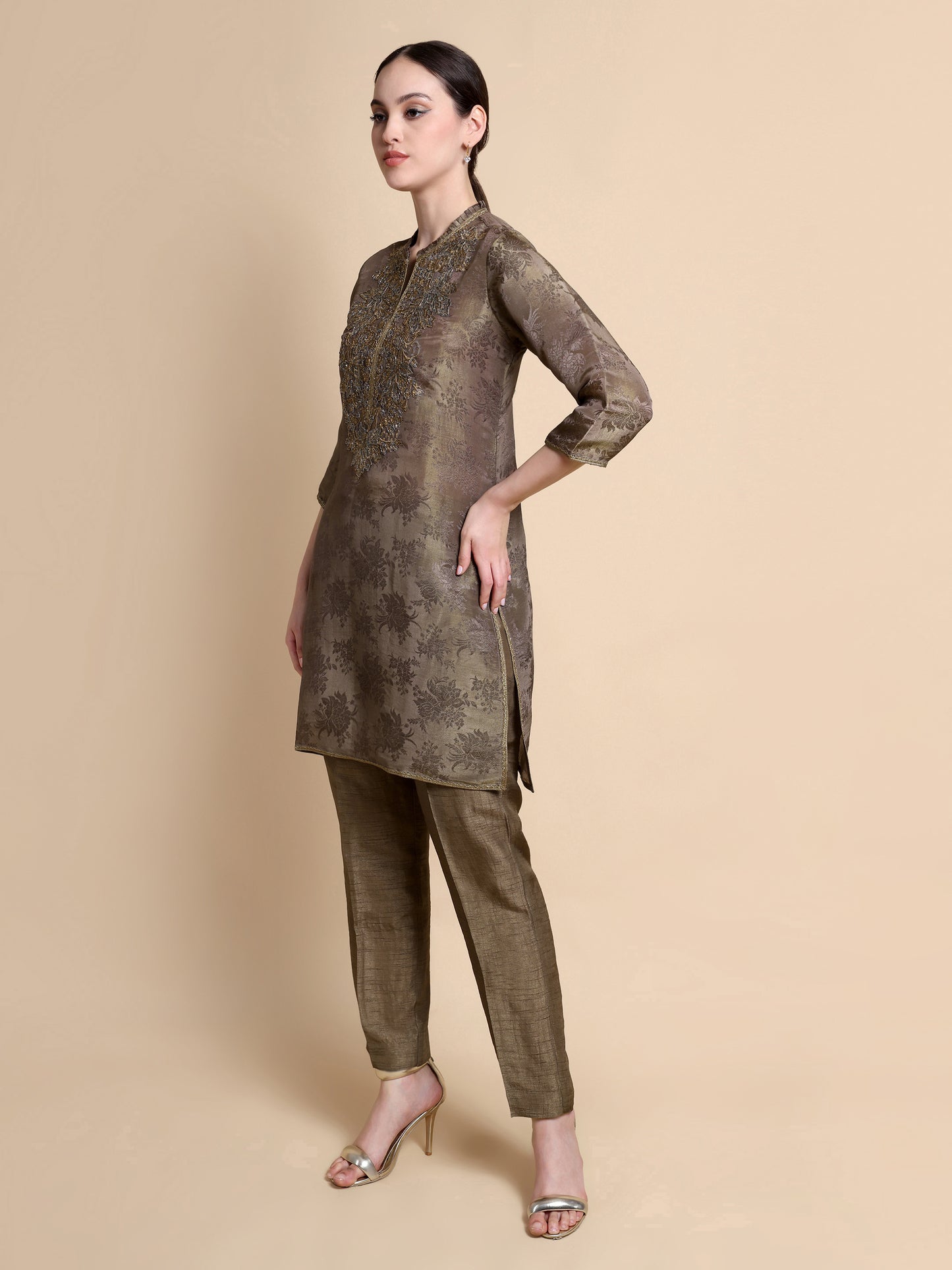 Woman wearing a brown traditional outfit with a beige background