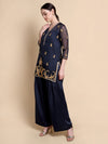 Woman wearing a navy blue traditional outfit with gold embroidery on a beige background