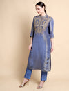 Woman wearing a blue embroidered kurta with pants on a beige background