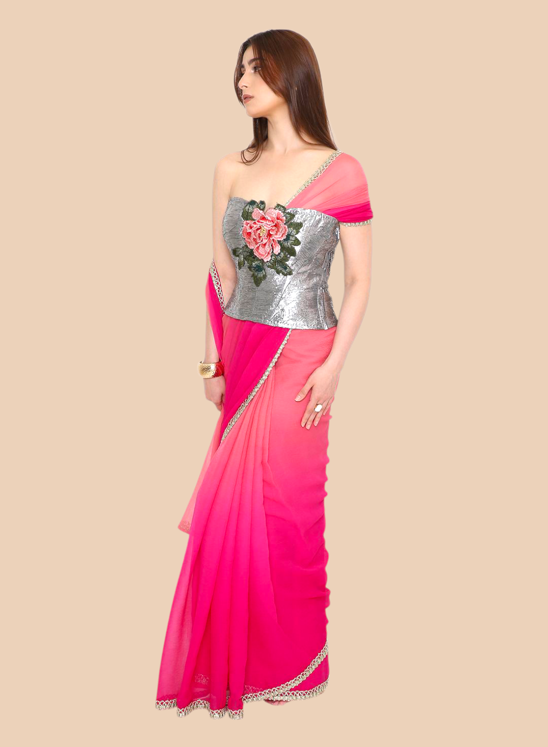 Woman wearing a pink corset with a silver blouse on a beige background