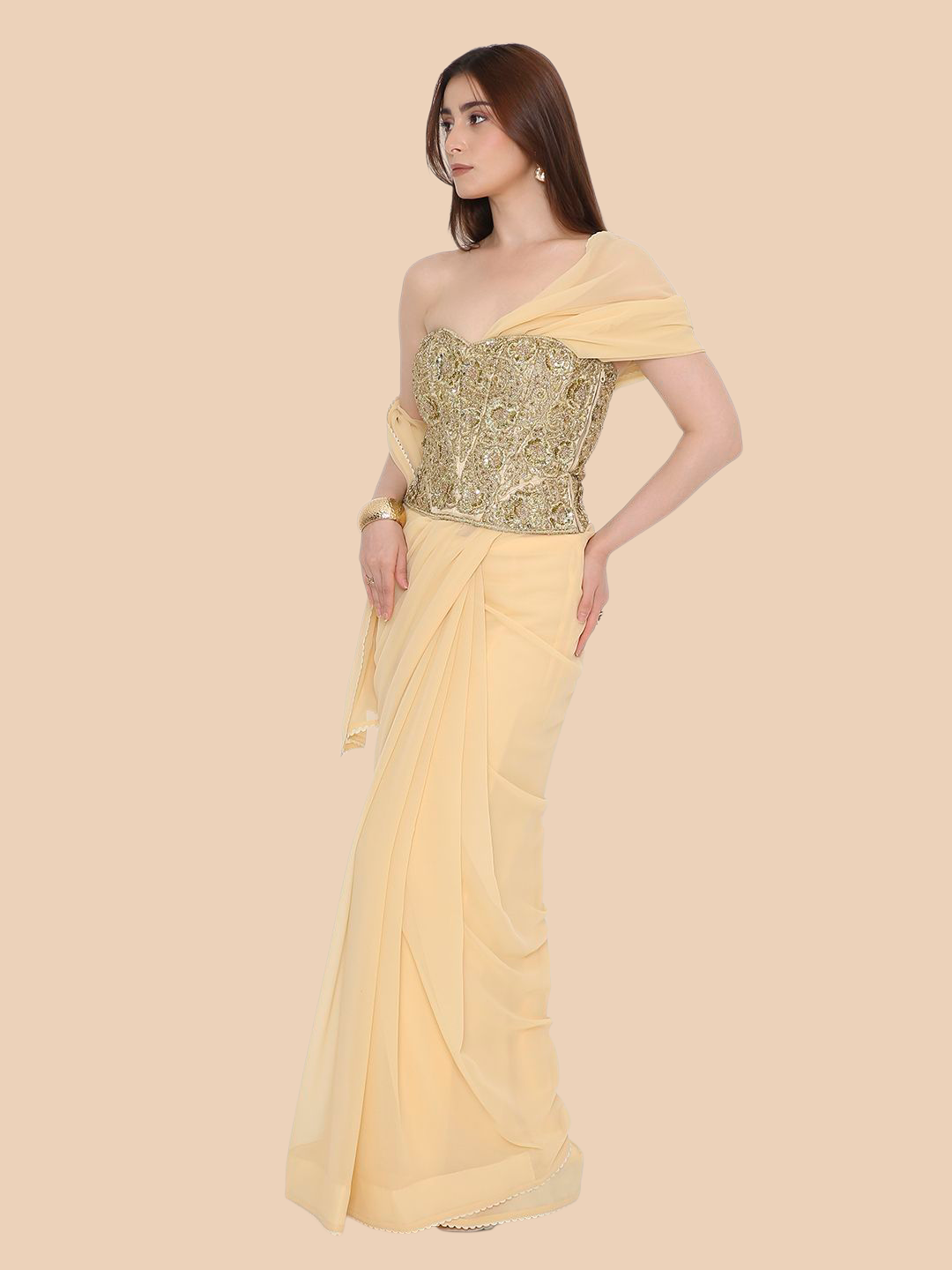 Woman wearing a yellow corset with a gold blouse on a beige background