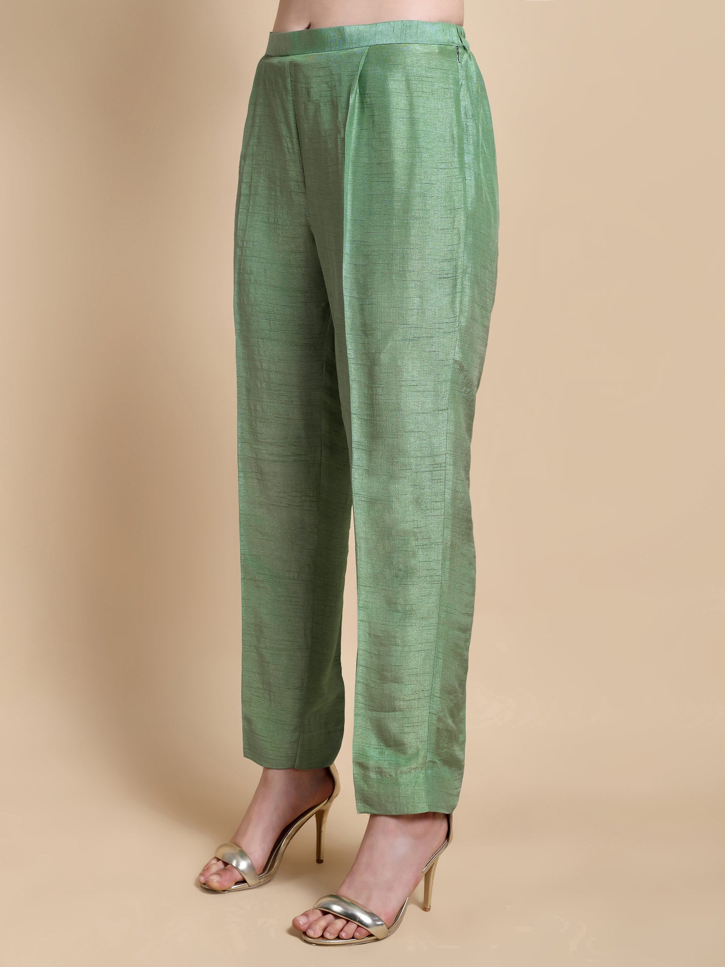 Green pants worn by a person on a beige background