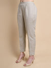 Light gray pants worn by a person on a beige background