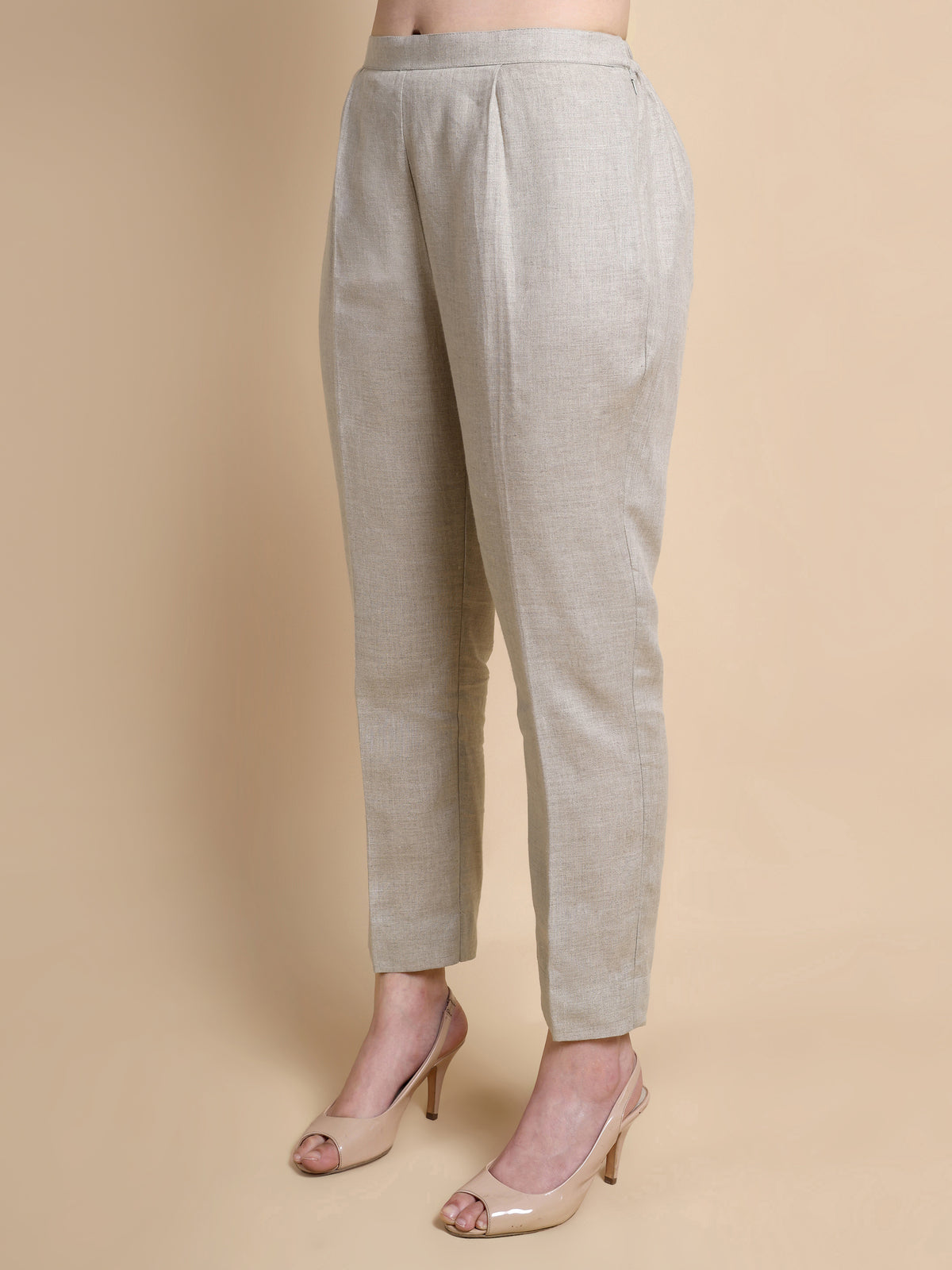 Light gray pants worn by a person on a beige background