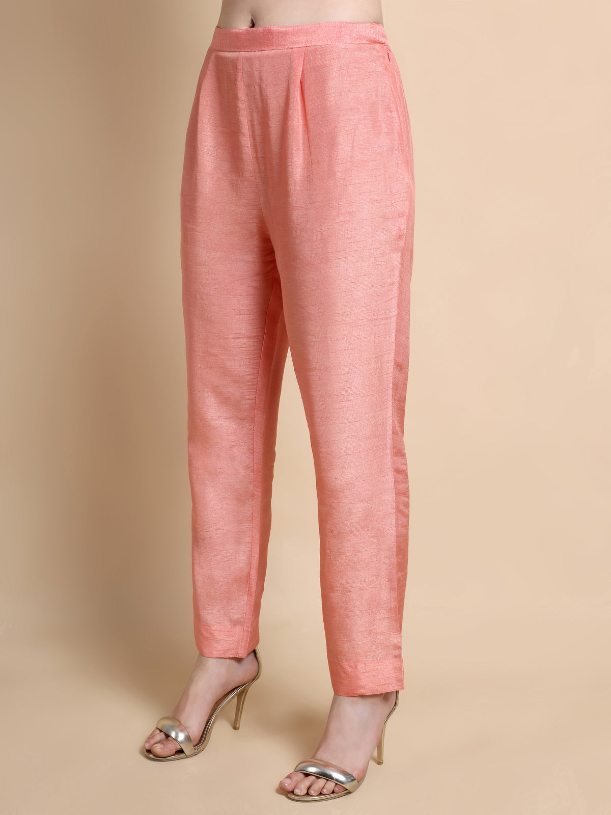 Pink pants worn by a person on a beige background