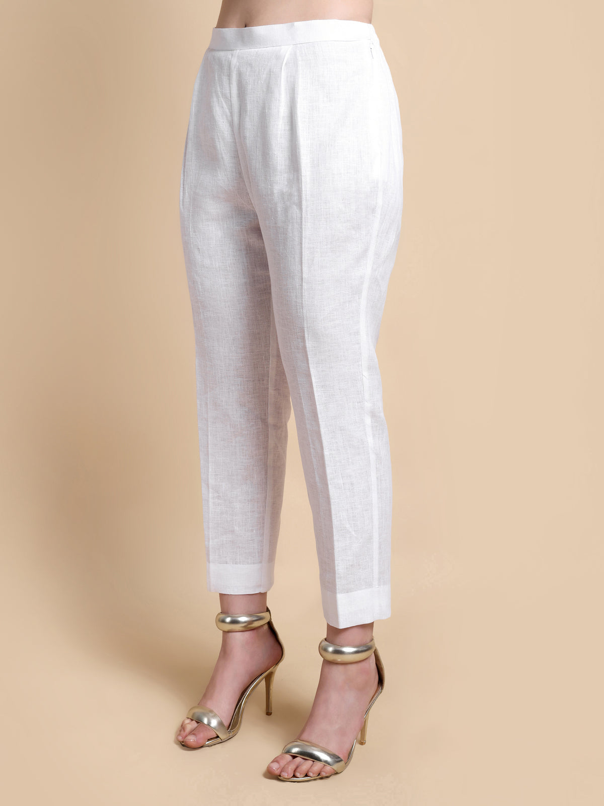 White pants worn by a person on a beige background