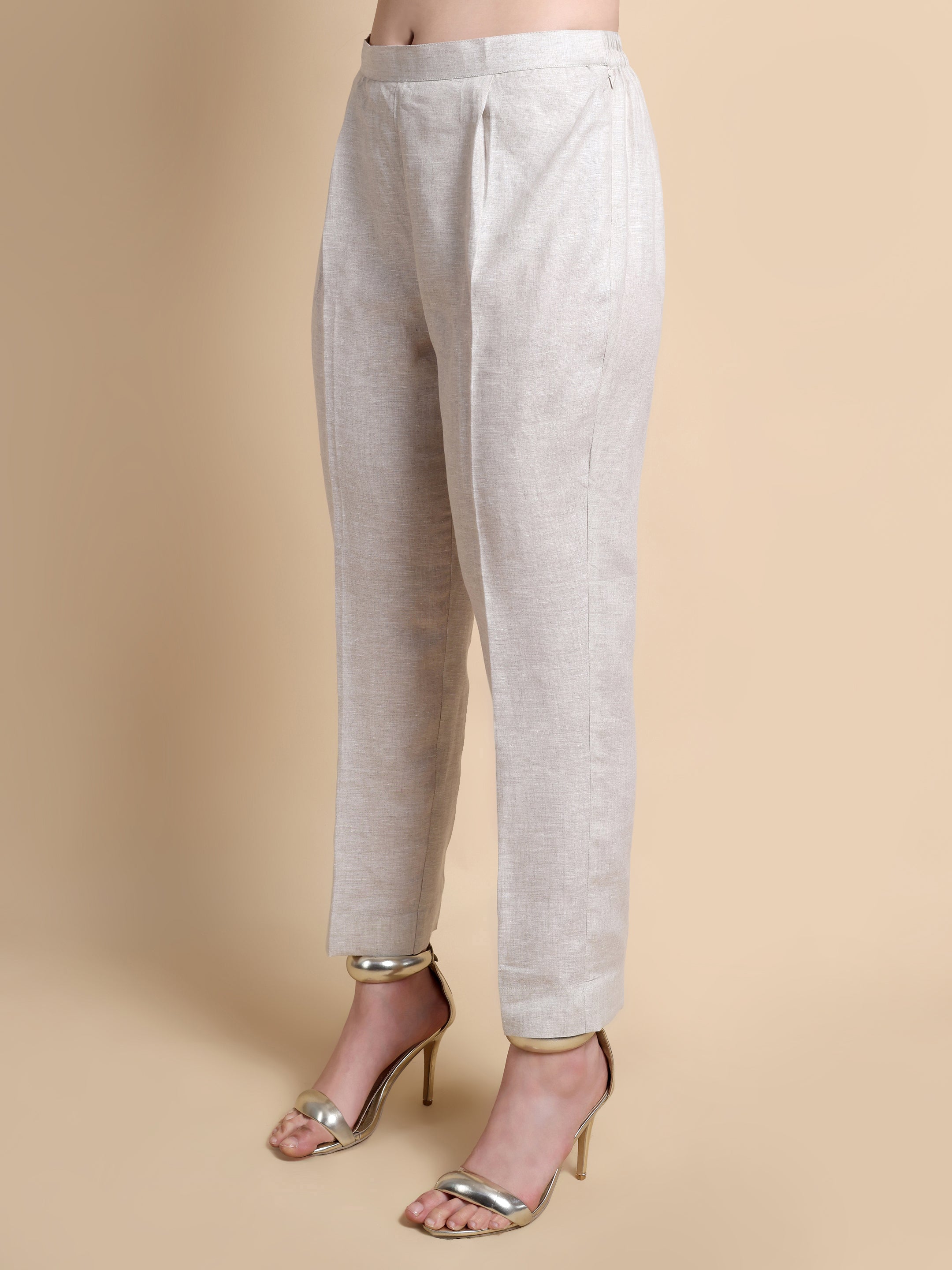 Light gray pants worn by a person on a beige background