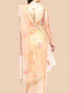 Luxurious peach net sari featuring floral embroidery, complemented by a sleeveless brocade blouse and unstitched petticoat.  