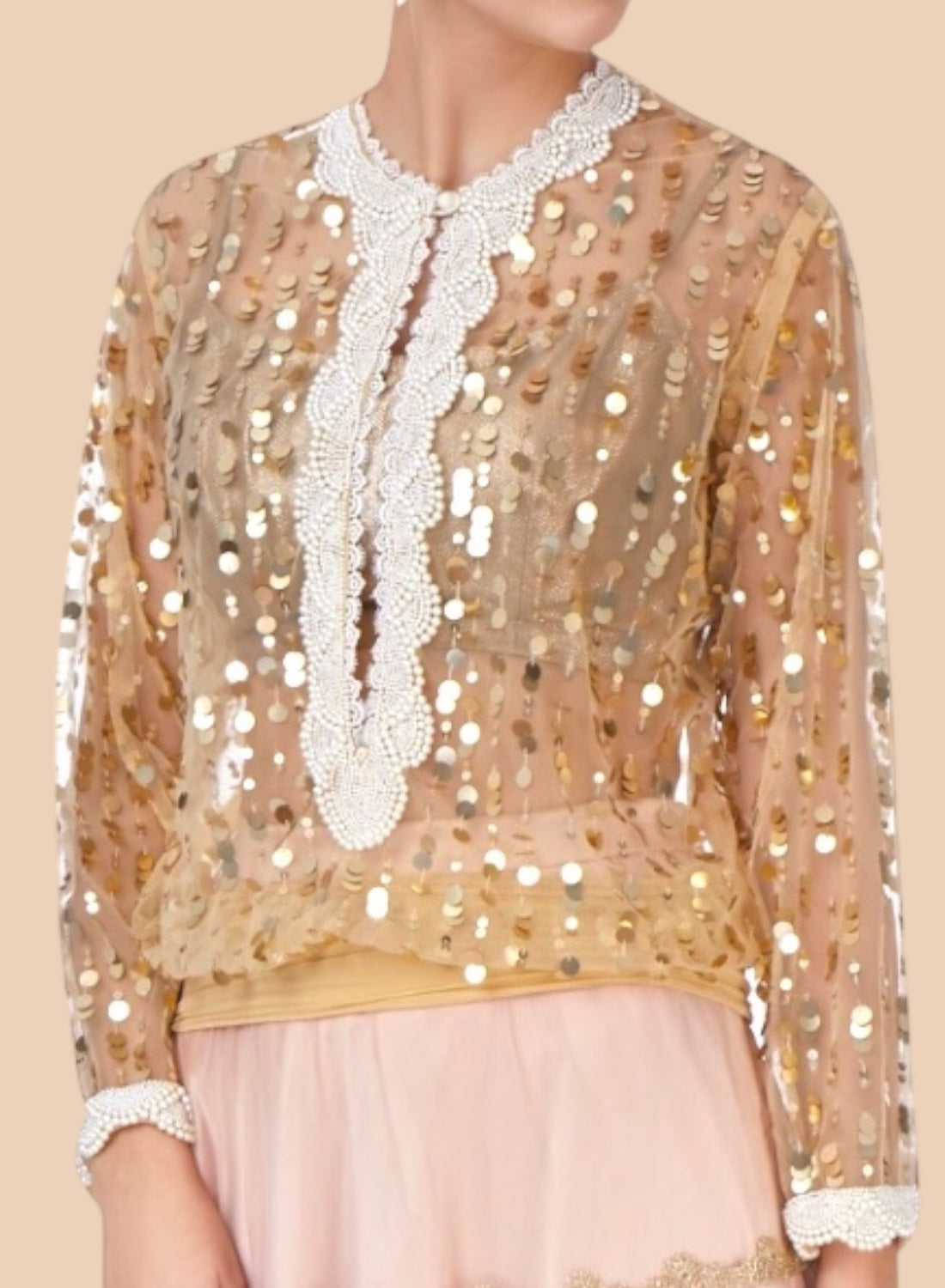 Elegant nude net blouse adorned with gold sequins and pearl embroidery at the neck and cuffs, exuding effortless style.  