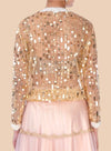 Elegant nude net blouse adorned with gold sequins and pearl embroidery at the neck and cuffs, exuding effortless style.  