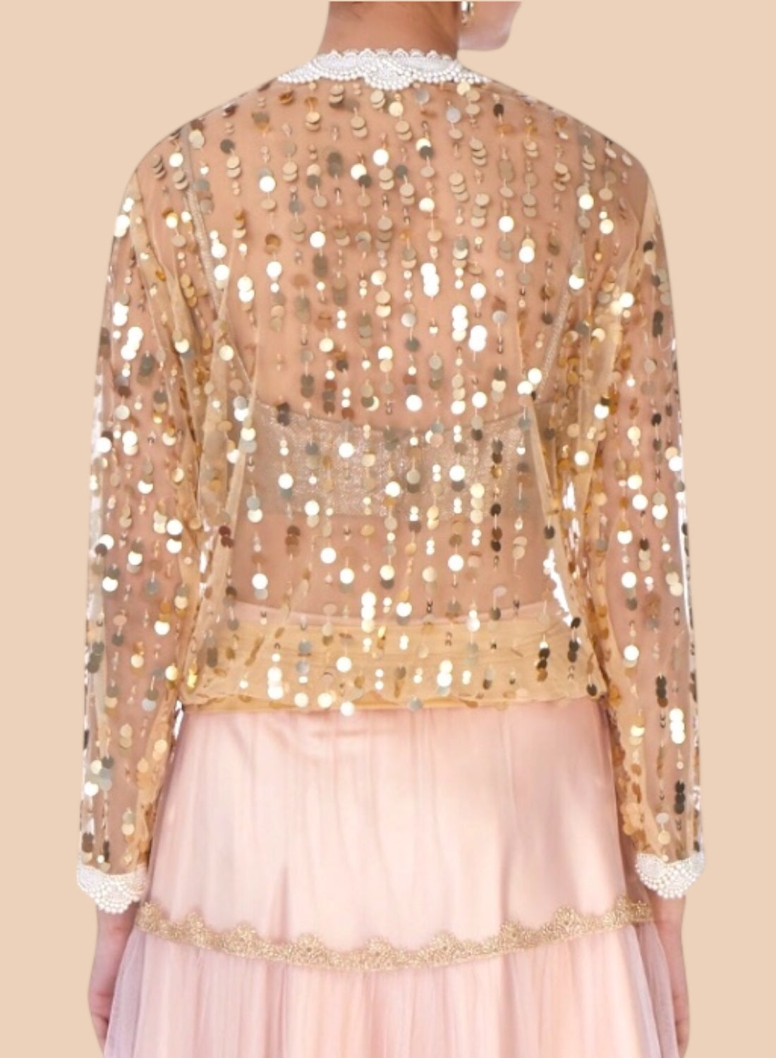 Elegant nude net blouse adorned with gold sequins and pearl embroidery at the neck and cuffs, exuding effortless style.  