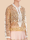 Elegant nude net blouse adorned with gold sequins and pearl embroidery at the neck and cuffs, exuding effortless style.  