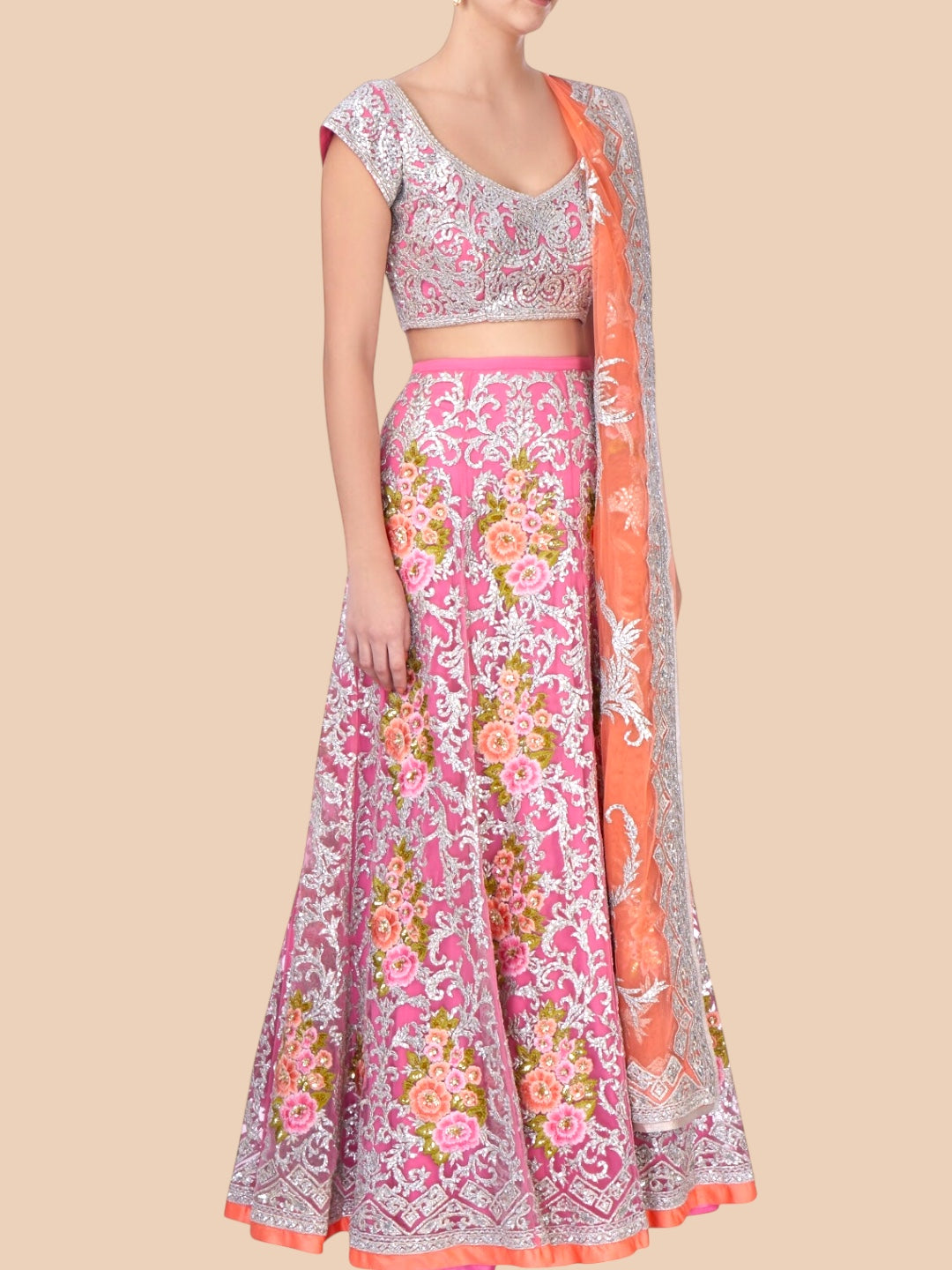 Traditional outfit with a pink floral skirt and matching blouse on a beige background
