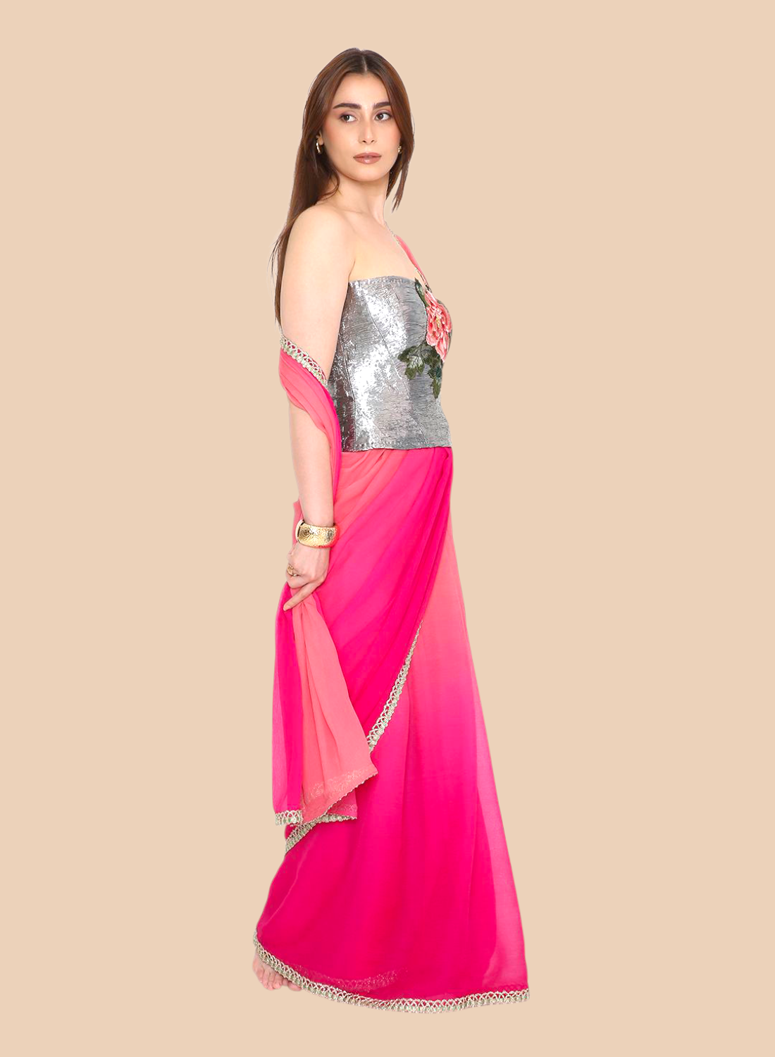 Woman wearing a pink and silver corset with a beige background