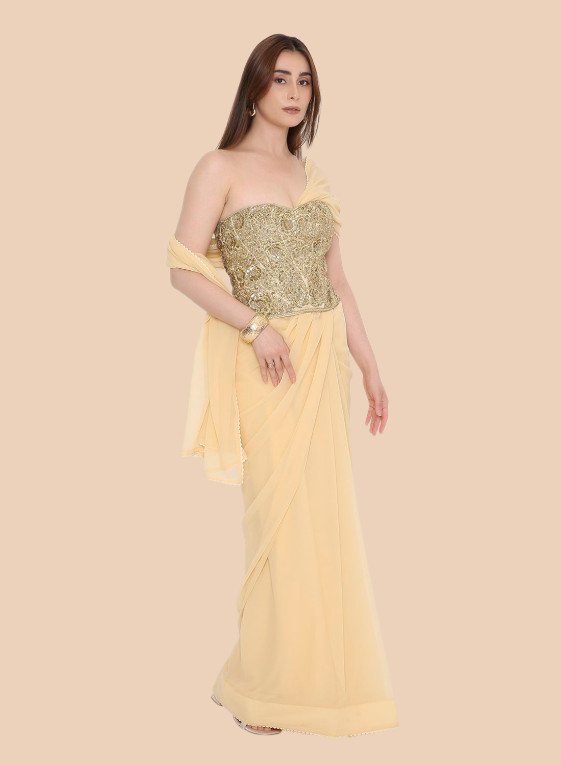 Woman wearing a yellow corset with a gold blouse on a beige background