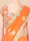 Orange saree with intricate gold and white embroidery on a beige background