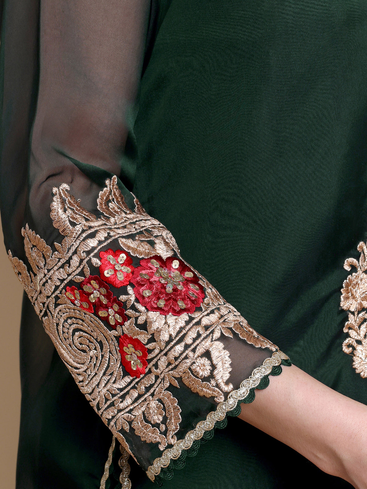 Close-up of a green garment with intricate gold and red embroidery