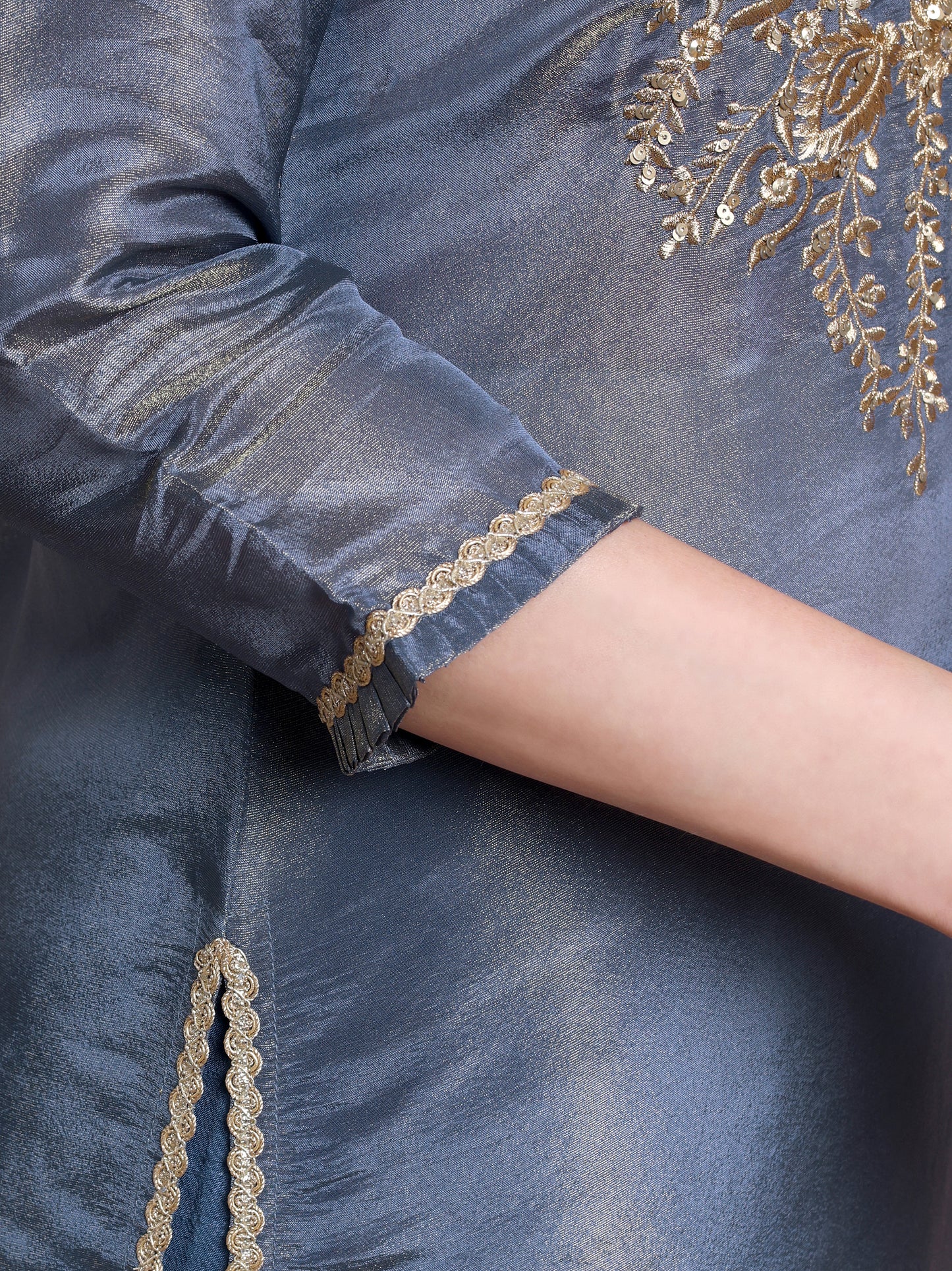 Navy blue fabric with gold embroidery on a person's arm