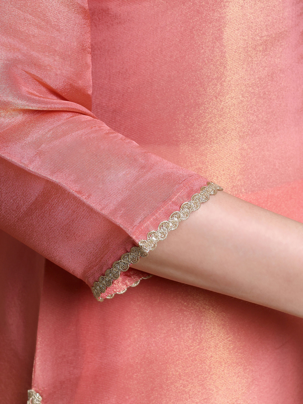 Close-up of a person wearing a bracelet on a pink fabric background