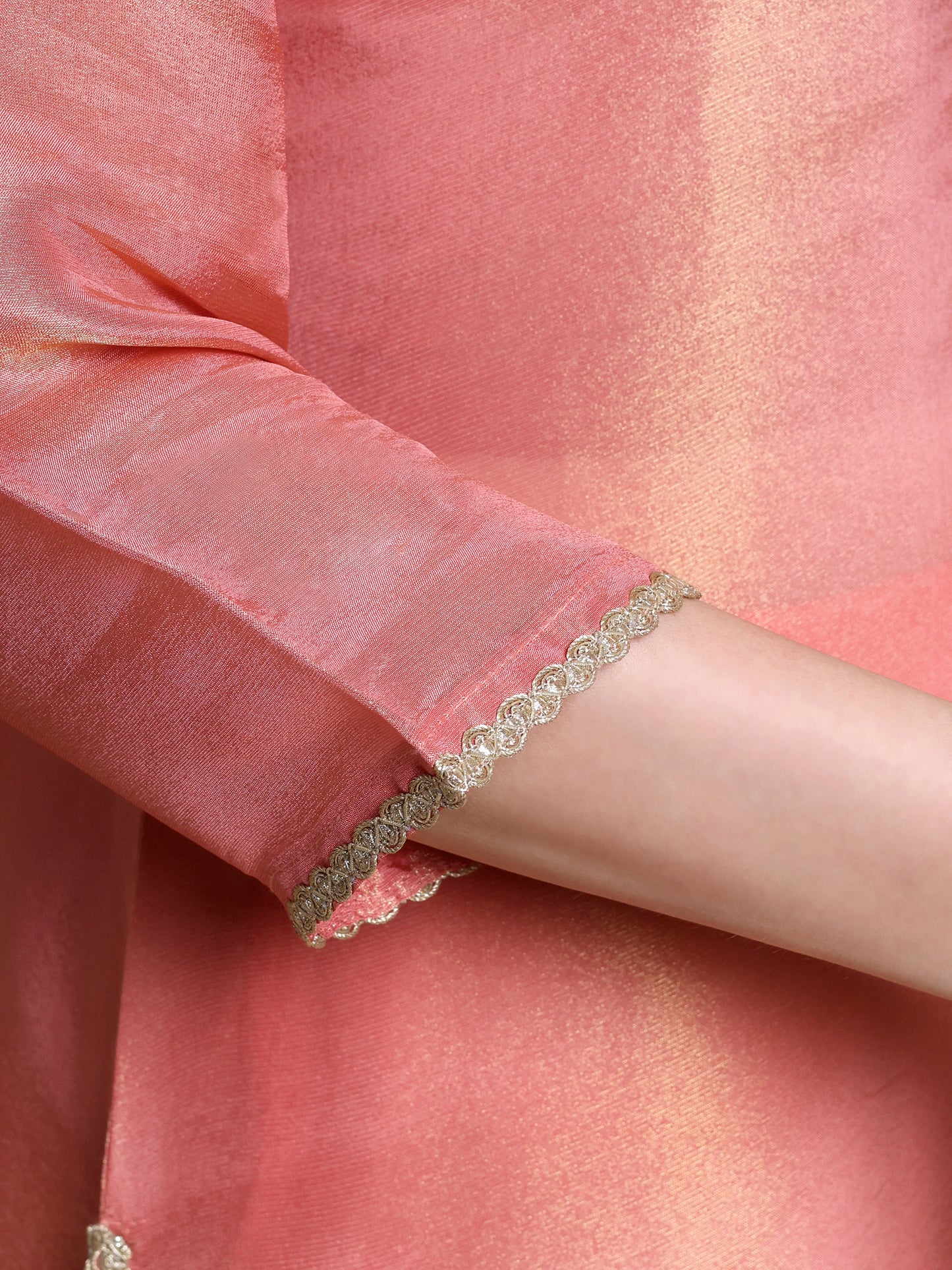 Close-up of a person wearing a bracelet on a pink fabric background