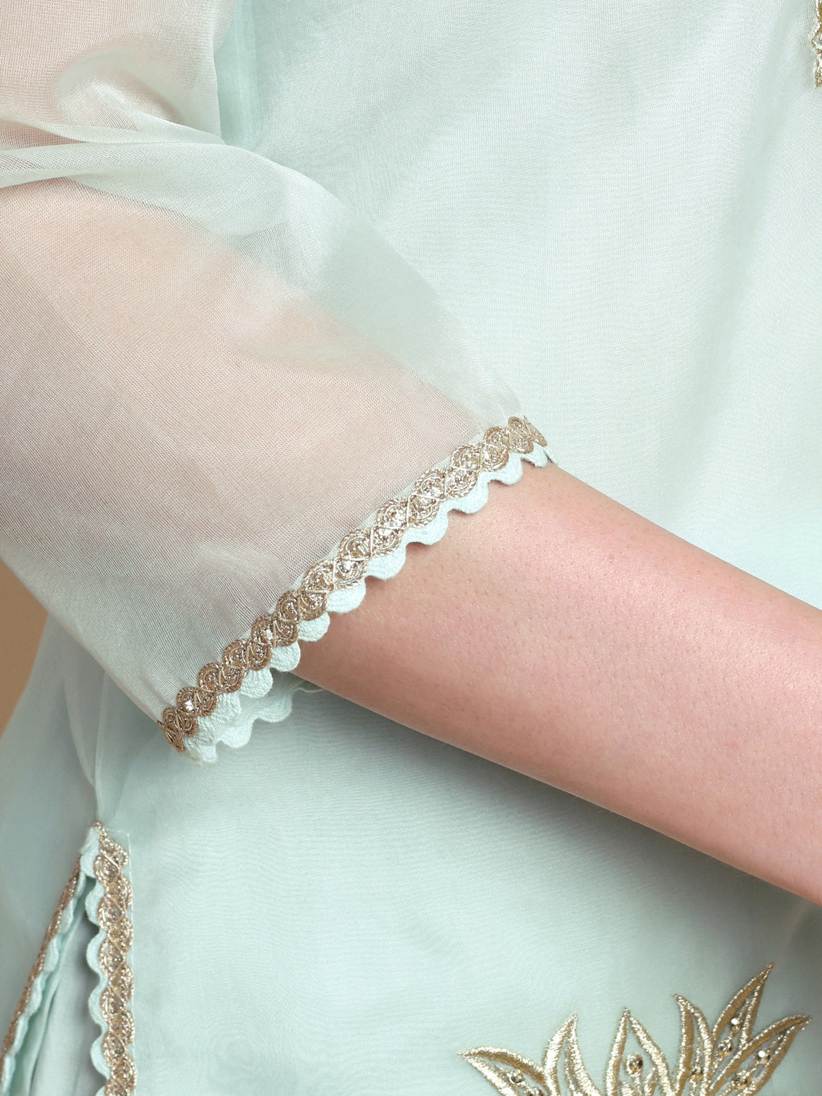 Close-up of a wrist wearing a delicate bracelet with a light background