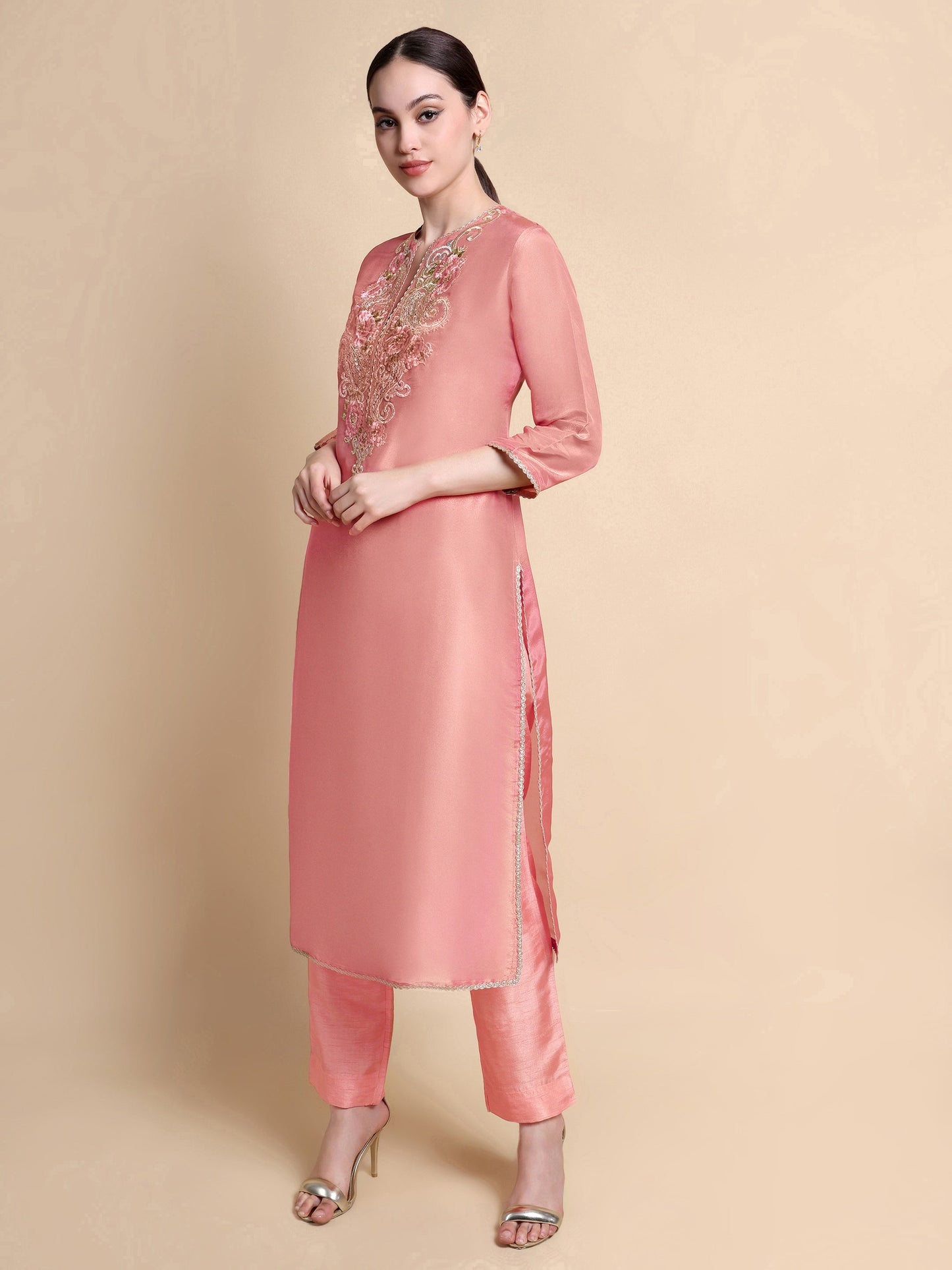 Side angle showing silhouette and embroidery of pink tissue kurta