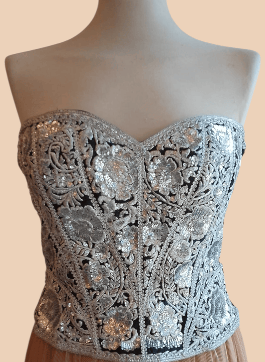 Close-up of intricate silver floral sequin embroidery on corset
